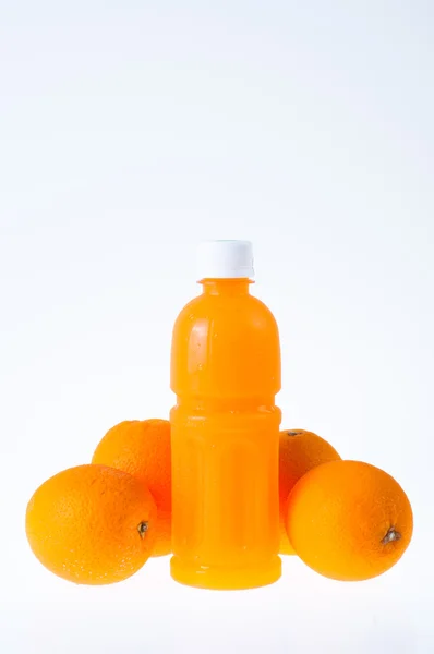 Zumo de naranja en una botella y naranja a su lado aislado en blanco —  Fotos de Stock