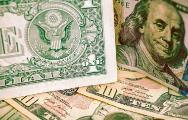 US dollar bills glued standing on bills scattered on a table. Concepts of personal finance, global crisis and economy.