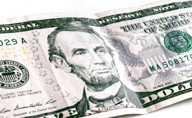 Money, US dollar banknotes background. Photography for Finance and Economy concept. A five-dollar banknote in close-up. 