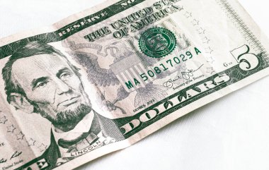 Money, US dollar banknotes background. Photography for Finance and Economy concept.  A five-dollar banknote in close-up. 