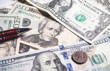United States dollar bills with a cent coin and red pen. Close up photography. Finance and Economy concept.