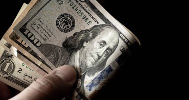 Close up of man holding in his hand notes varying values of United States dollars