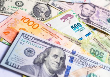 Argentinian pesos. Money notes of the argentine's currency and a US dollar bills to represent the foreign exchange theme. 