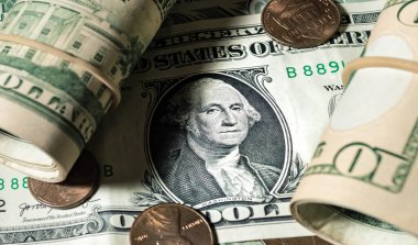 Close up of money background with dollar banknotes rolled up and coins. Economy and finance concept.