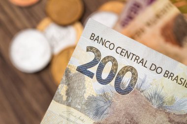Real, money from Brazil. Dinheiro, Reais, Real Brasileiro, Brasil. Brazilian banknotes in close-up. A brazilian banknote of 200 Reais and coins in close up.