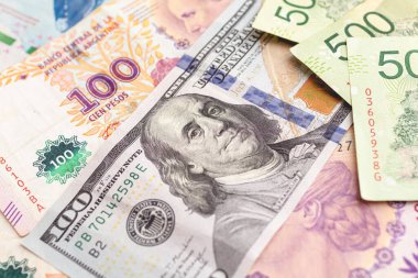 Argentininan pesos. Money notes of the argetina's currency and a US dollar bill to represent the foreign exchange theme.