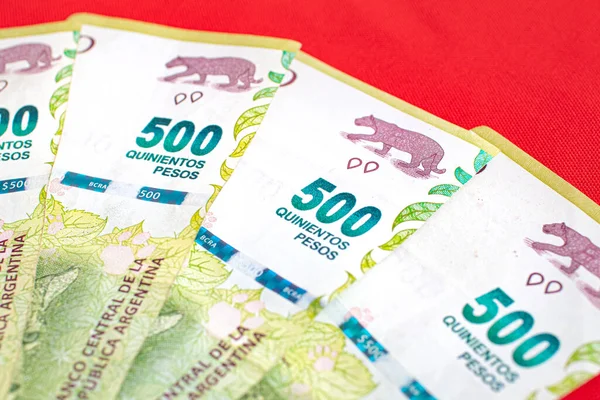 Peso banknotes of the money of the argetine currency, the Argentine peso, on a wooden desk. Photo for representation of economy and finance.