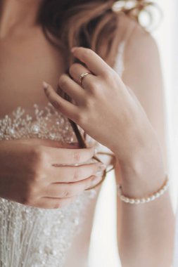 Delicate touch of elegance in a bride's preparation on her special day with intricate details and soft morning light