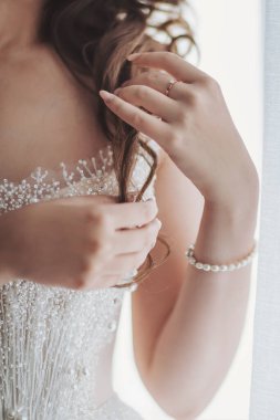 Delicate touch of elegance in a bride's preparation on her special day with intricate details and soft morning light