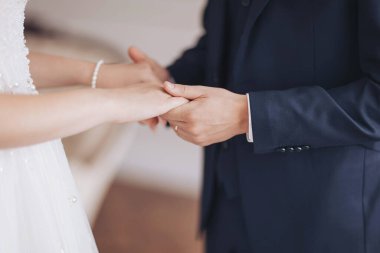 Holding hands in a tender moment during a wedding ceremony, showcasing love and commitment in a beautifully decorated venue