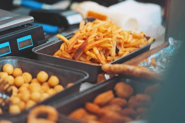 Crispy delights at a bustling market stall filled with golden fries and savory snacks during a sunny afternoon