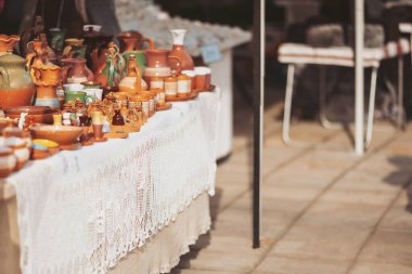 Colorful ceramic crafts displayed at an outdoor market on a sunny day in a vibrant community setting showcasing local artisans