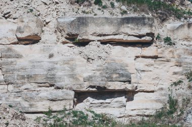 White chalk cliffs rise majestically under a clear blue sky, showcasing nature's artistry during the calm of a sunny day
