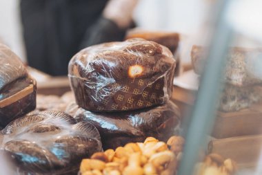 Sıcak bir fırında sergilenen şeffaf plastiğe sarılı lezzetli hamur işleri müşterileri tatlı tatlara ve sıcak aromalara davet ediyor.