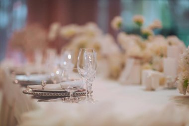 Şık bir yemek masası, köpüklü bardaklar ve rafine sofra takımı. Özel bir durum için çok iyi düzenlenmiş.