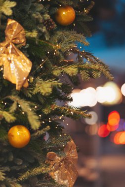 Güzel dekore edilmiş Noel ağacı altın süsler ve ışıltılı ışıklarla bayram sezonunda şenlikli bir atmosfer yaratıyor.