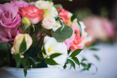 Baharda bir düğün resepsiyonunda yeşillikle süslenmiş güzel pembe ve beyaz güller.