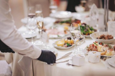 Garson kirli tabakları temizler. Güzel düzenlenmiş yemekler ve servis ile resmi bir etkinlik sırasında iyi dekore edilmiş bir yemek salonunda şık bir akşam yemeği hazırlamak.. 