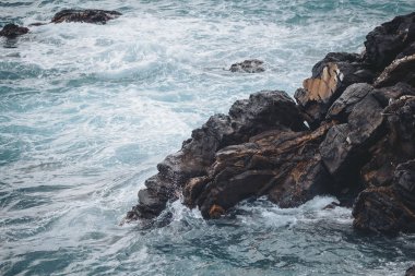 Kıyı şeridine vuran dalgalar bulutlu bir günde hafif dalgalar ve köpüklerle sakin ve doğal bir atmosfer oluşturur.