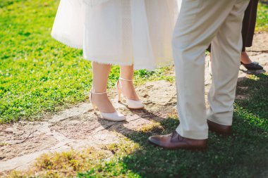 Güneşli bir günde, düğün sırasında taş bir yolda dikilen çift yakınlarda törene hazırlanıyor.