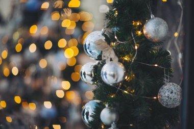 Noel ağacının süsleri ve süslemeleri, tatil sezonunda, parlak ışıklarla dolu kapalı bir ortamda.