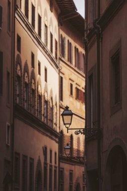 Günbatımı Floransa 'nın dar sokaklarında sıcak bir parıltı yayarak bu tarihi şehrin karmaşık mimarisini ve cazip atmosferini vurguluyor. Fenerler yavaşça parlıyor, sihir yaratıyor.