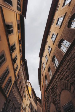 Floransa 'nın dar ve büyüleyici sokaklarında dolaşarak, Toscana, antik taş duvarların yükseldiği kara kara düşünen gökyüzüne karşı, keşif ve maceraya davetiye çıkararak. İtalya, Floransa, 2025