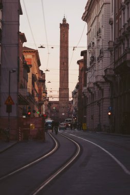 Güneş batarken Bologna 'nın dar caddelerinde renkli binalar sıralanır ve yüksek simgelerin üzerine sıcak bir parıltı yayar. İnsanlar bu Toskana cevherinin canlı atmosferinin tadını çıkararak rahatça yürüyorlar.