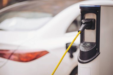 Yüzeyde parlayan yağmur damlaları gibi elektrikli bir araç şık bir istasyondan şarj alır. Sahne, hareketli şehir hayatının ortasında teknoloji ve doğa karışımını yakalıyor.