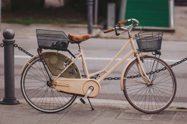 Kaldırım kenarında duran klasik bir bisiklet sepetler ve yumuşak, sessiz bir renk gibi karmaşık detaylar içerir. Bisiklet, şehir hayatının özünü yakalar, keşif ve maceraya davetiye çıkarır.