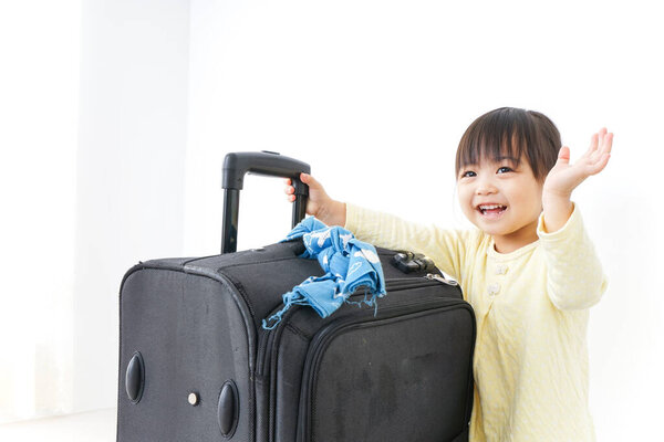 Child carrying a suitcase