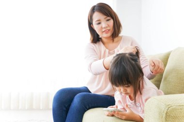 Anne çocuğun kıyafetlerini ayarlıyor..