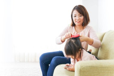 Anne çocuğun kıyafetlerini ayarlıyor..