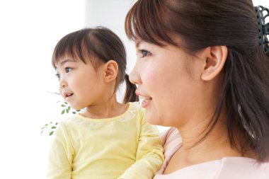 Anne kucağında çocuğu taşıyor..