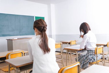  Sınıfta sandalyede oturan öğrenci..