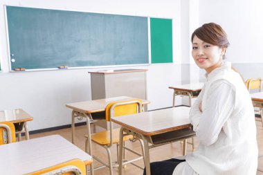 Sınıfta sandalyede oturan öğrenci..