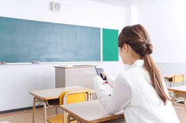 _ a _ mobile _ phone _ in _ class _ in _ kim _. Sınıfta akıllı telefon kullanan öğrenci.
