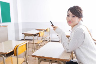 _ a _ mobile _ phone _ in _ class _ in _ kim _. Sınıfta akıllı telefon kullanan öğrenci.