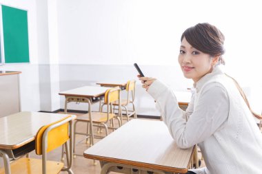 _ a _ mobile _ phone _ in _ class _ in _ kim _. Sınıfta akıllı telefon kullanan öğrenci.