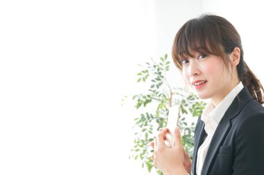 Takım elbiseli kadın akıllı telefon kullanıyor..