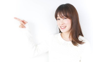 Güzel genç bir kadın bir şeyi işaret ediyor.