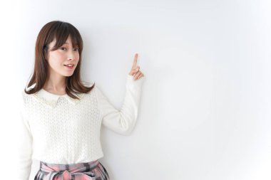 Güzel genç bir kadın bir şeyi işaret ediyor.