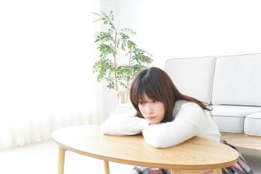 Evde dizüstü bilgisayar kullanan genç bir kadın.