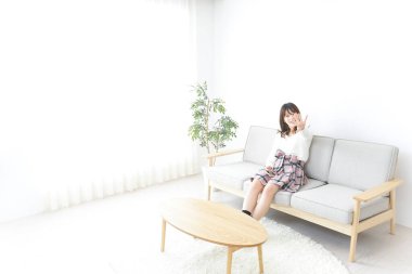 Evde dizüstü bilgisayar kullanan genç bir kadın.