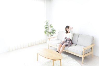 Evde dizüstü bilgisayar kullanan genç bir kadın.