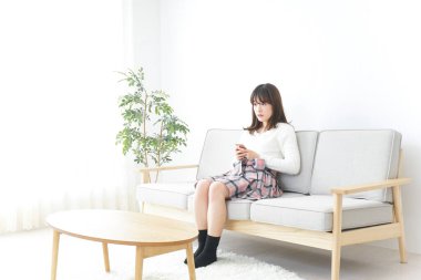 Evde dizüstü bilgisayar kullanan genç bir kadın.