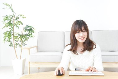 Evde bilgisayar kullanan genç bir kadın.