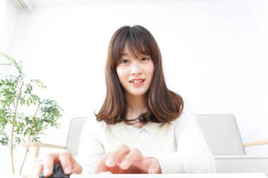 Evde bilgisayar kullanan genç bir kadın.