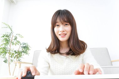 Evde bilgisayar kullanan genç bir kadın.