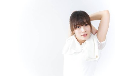 Beyaz arka planda egzersiz yapan genç bir kadın. 